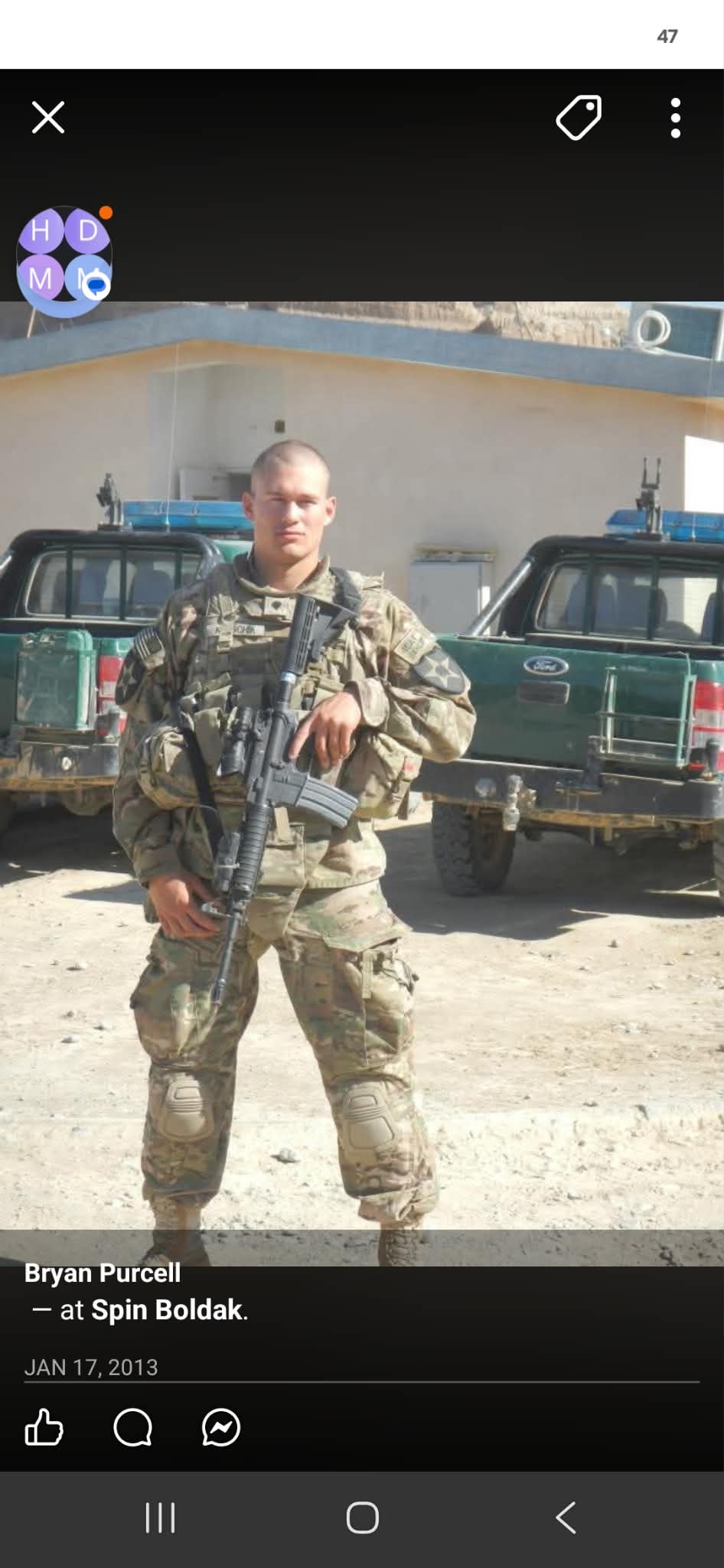 Aurey Kunschik in uniform and body armour during his Army service, two pickups behind him